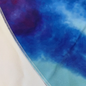 Close-up of overlock stitching on gradient starry blue round beach towel edges