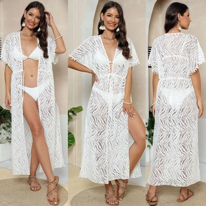 Detail of white lace beach cover-up with tassel trim and mesh wave texture