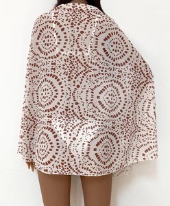 Detail view of semi-transparent brown polka dot beach cover-up with tie-up wrap design
