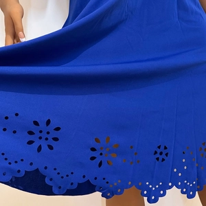 Detailed laser-cut floral hollow pattern on the hem of a royal blue short sleeve dress