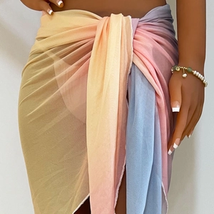Detail of multi-color gradient tie-dye beach wrap skirt with semi-sheer fabric and tie-up waist