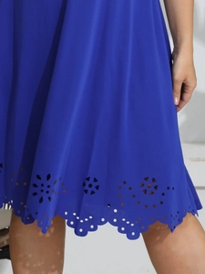Detail of laser-cut floral patterns and scalloped hem on the royal blue dress fabric