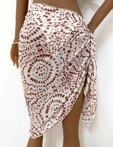 Detailed close-up of white semi-transparent polka dot wrap skirt with side tie ribbon