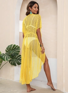 Detail of yellow crochet beach cover-up with intricate geometric openwork and side slits