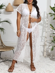 Dettaglio copricostume in pizzo bianco con pompon sui polsini e trama a onde delicate