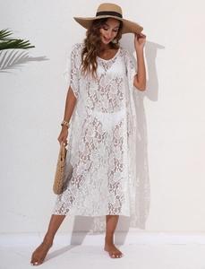 Detailed texture of white lace crochet beach cover up with hollow floral patterns