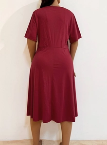 Detail view of the back of a burgundy short-sleeve dress with round neck and waist cut