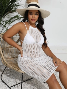Détail d'une robe de plage blanche en crochet ajouré avec dos nu et col licou chic