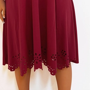 Detailed view of the laser-cut scalloped hem on a wine red plus size fashion dress