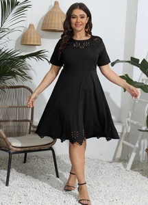Detail of laser-cut floral embroidery on a black plus-size short sleeve dress