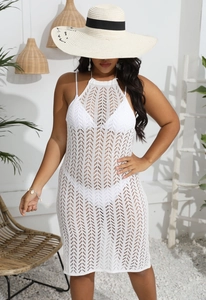Gros plan détaillé de la robe de plage en crochet blanc avec des motifs ajourés complexes