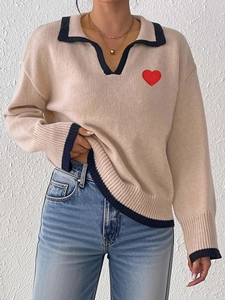 Beige knit sweater with contrast navy lapel collar and red heart patch detail