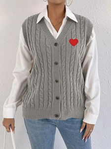Detail of grey cable knit vest with vintage buttons and red heart embroidery patch