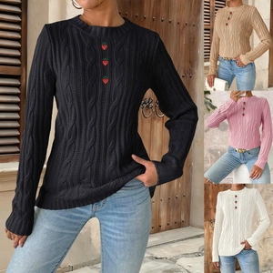 Detail view of knit sweater showing cable stitch pattern and strawberry-shaped buttons