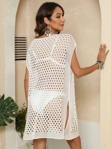 Detailed macro view of white crochet beach cover-up featuring side slits and mesh knit texture