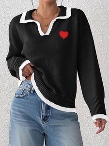 Detail of red heart embroidery and contrast trim on women's knit long sleeve polo sweater