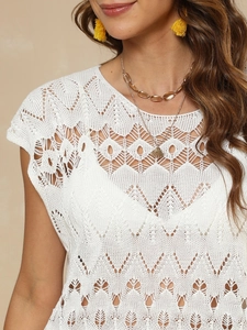 Close-up of white crochet beach cover-up featuring geometric hollow patterns
