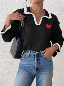 Women's black knit sweater with white polo collar and a red heart embroidery patch