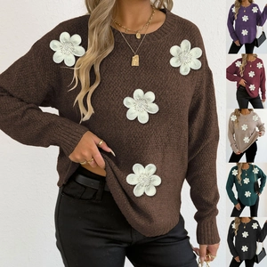 Close-up of 3D white floral appliques and knit texture on the crew neck sweater