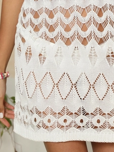 Detailed view of white crochet beach skirt featuring intricate hollow-out knit patterns