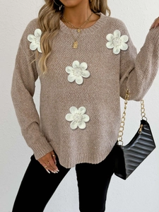 Detailed view of 3D white floral embroidery on a brown knit sweater with a ribbed crew neck