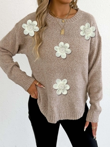 Detail of oatmeal knit sweater with 3D white floral embroidery and irregular split hem