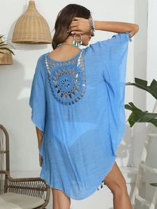 Détail macro du cache-maillot bleu ciel avec motif mandala crocheté complexe au dos