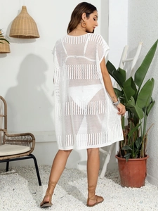 Dettaglio del copricostume bianco all'uncinetto con intricati motivi in maglia traforata