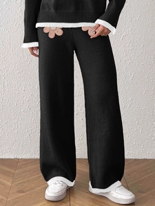 Completo in maglia nera da donna con fiori ricamati e pantaloni a gamba larga a contrasto