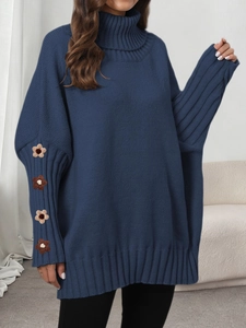 Detail of crochet flower patches on dark blue high-neck sweater with textured knit fabric