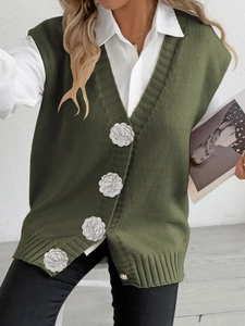 Green knit vest with 3D white flowers and pearl buttons over white long-sleeve shirt