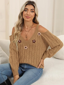 Detail showing the cable knit texture and 3D floral accents on this brown cold-shoulder sweater