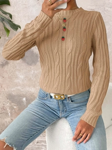 Detailed view of beige cable knit sweater featuring decorative strawberry buttons