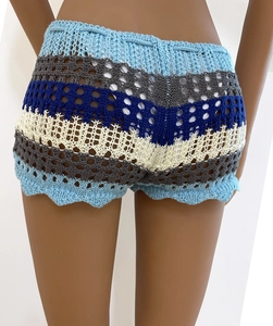 Detail of colorful crochet shorts with hollow weave pattern and wavy hemline on mannequin