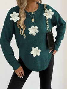 Detail of green knitted sweater with white 3D flower appliques and bead embellishments