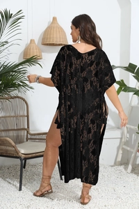Detail of black crochet floral lace beach cover-up with stylish side slit and tassels
