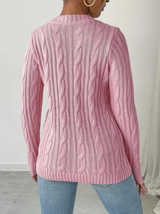Detail of pink cable knit texture and ribbed hem on a women's fitted sweater back view