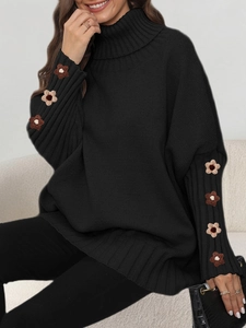 Detail of hand-crocheted floral pattern on the sleeve of a black turtleneck sweater