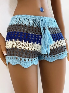 Detail of crochet knit beach shorts with colorful stripes, hollow out design and wavy hem