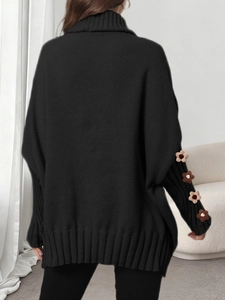 Detailed close-up of handmade crochet flower patterns on a black turtleneck sweater sleeve
