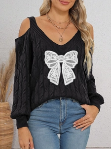 Close-up of black cable knit sweater with white lace bow and cold shoulder detail