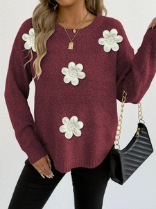 Detail view of burgundy knit sweater featuring white 3D floral embroidery and round neckline