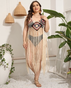 Detail of crochet bodice with long fringe hem on a bohemian style beach cover-up dress