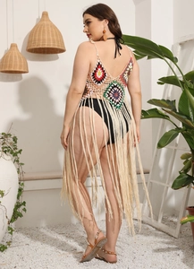 Detail of colorful crochet flower patterns and long beige cotton tassels on a beach cover-up