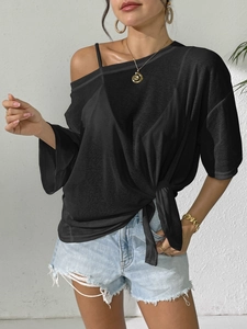 Detail of black off-shoulder beach cover-up with stylish front tie knot design