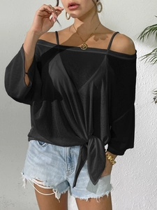 Detail of black off-shoulder blouse with adjustable side tie knot and lightweight fabric