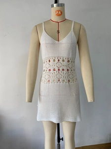 Détail de robe de plage en maille blanche avec motifs ajourés complexes à la taille