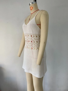 Détail de la robe d'été en crochet blanc avec des motifs ajourés géométriques à la taille