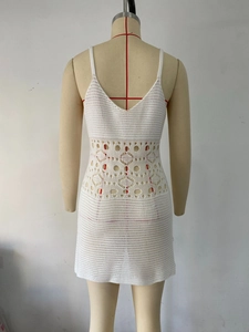 Détail d'une robe courte en maille crochet blanche avec motifs ajourés géométriques