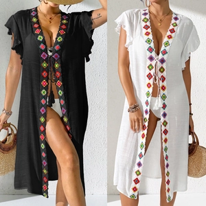 Detail of bohemian beach cover up featuring colorful geometric embroidery and tassel ties